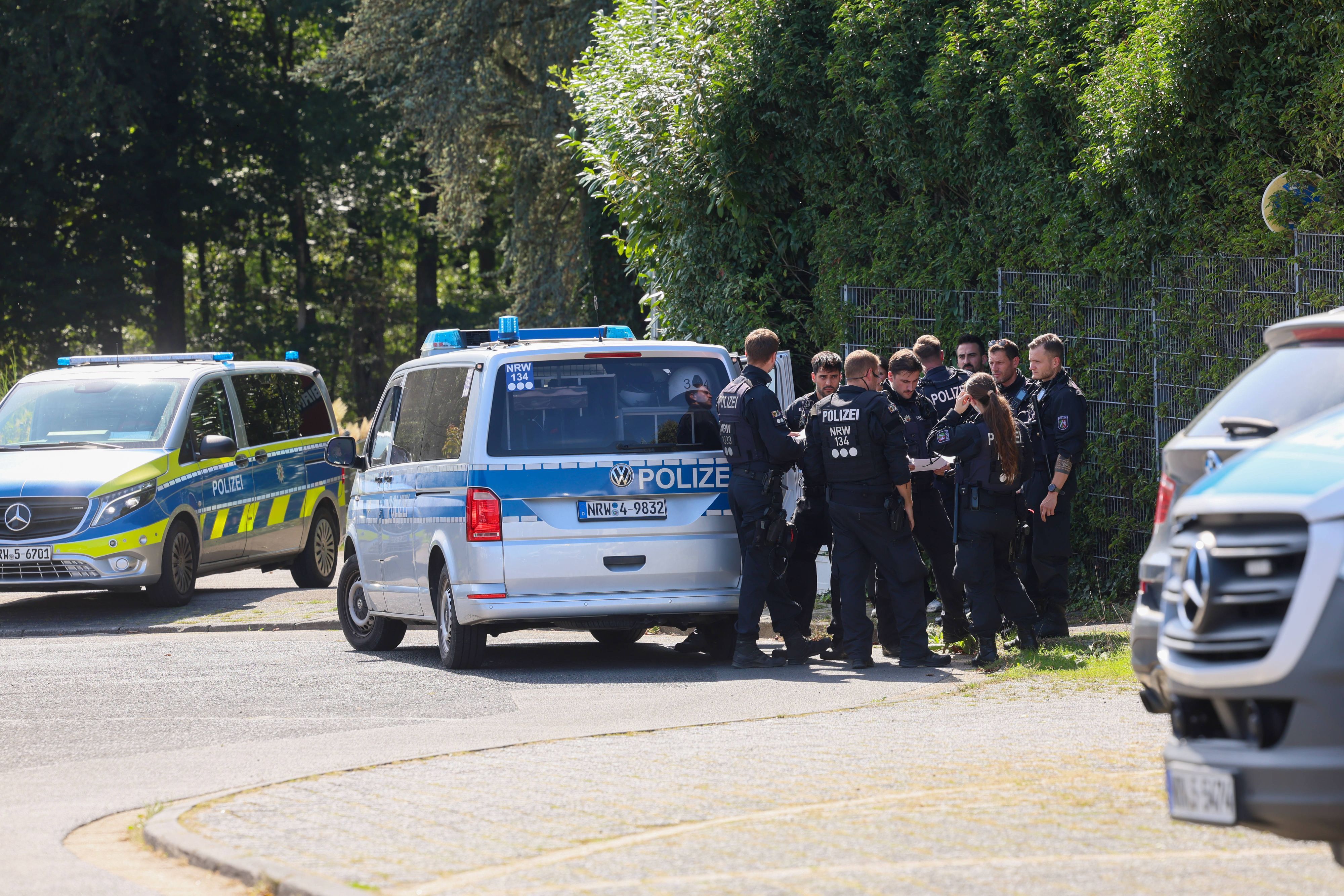 Polizisten rund um ein Einsatzfahrzeug bei einer Fahndungsmaßnahme.