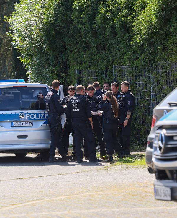 Polizisten rund um ein Einsatzfahrzeug bei einer Fahndungsmaßnahme.