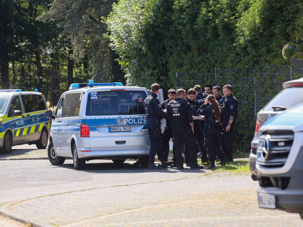 Polizisten rund um ein Einsatzfahrzeug bei einer Fahndungsmaßnahme.
