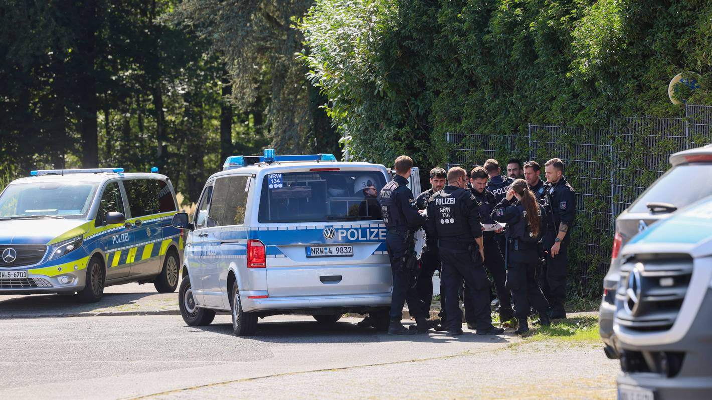 Polizisten rund um ein Einsatzfahrzeug bei einer Fahndungsmaßnahme.