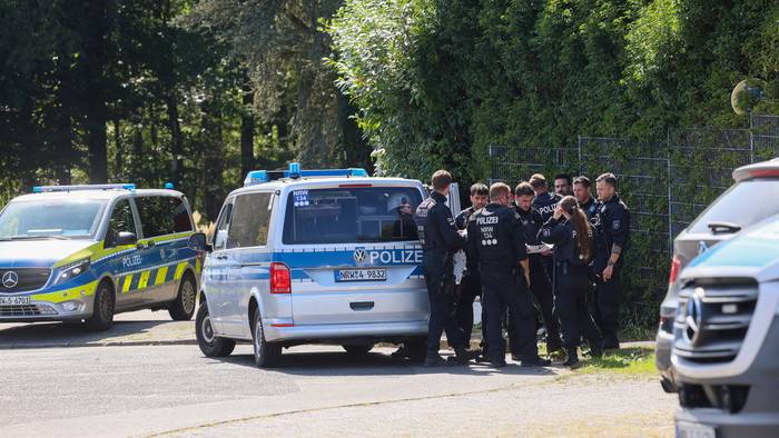 Polizisten rund um ein Einsatzfahrzeug bei einer Fahndungsmaßnahme.