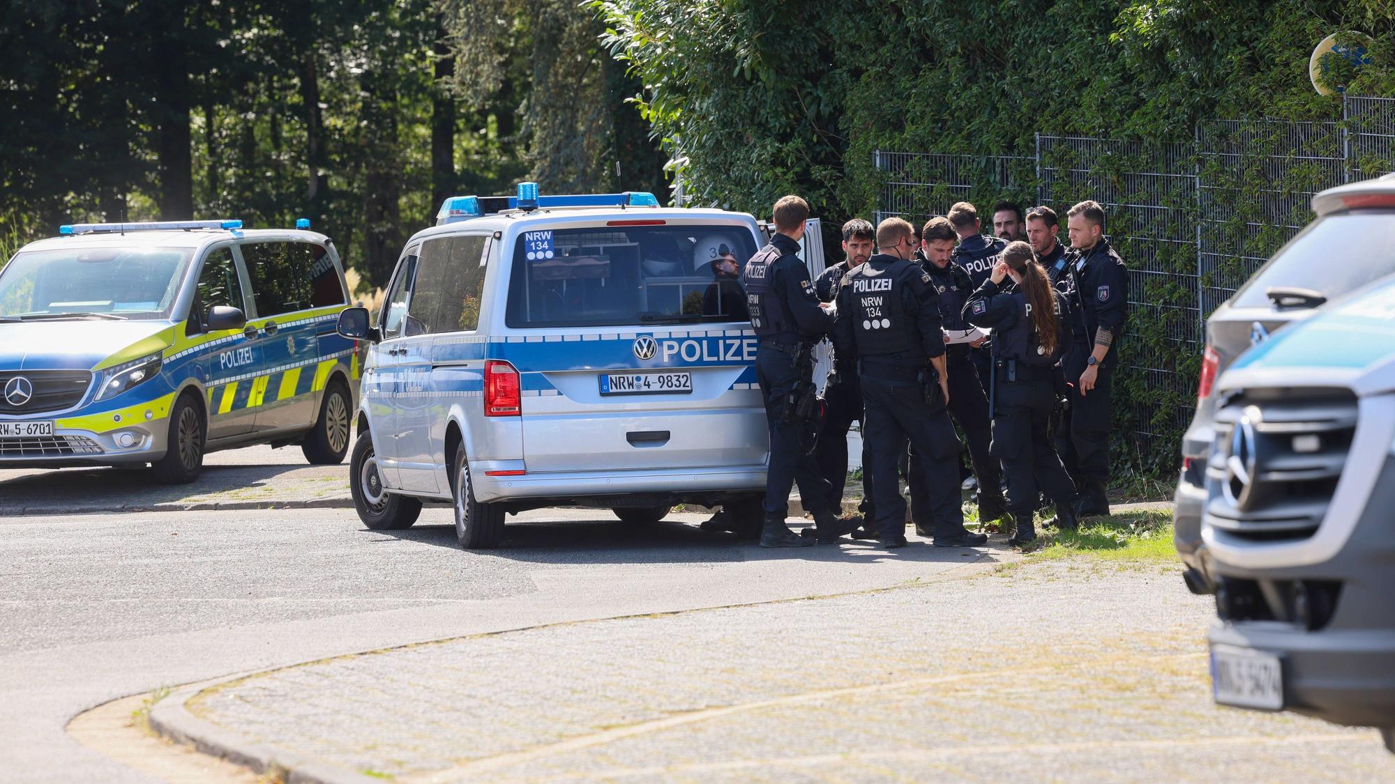 Polizisten rund um ein Einsatzfahrzeug bei einer Fahndungsmaßnahme.