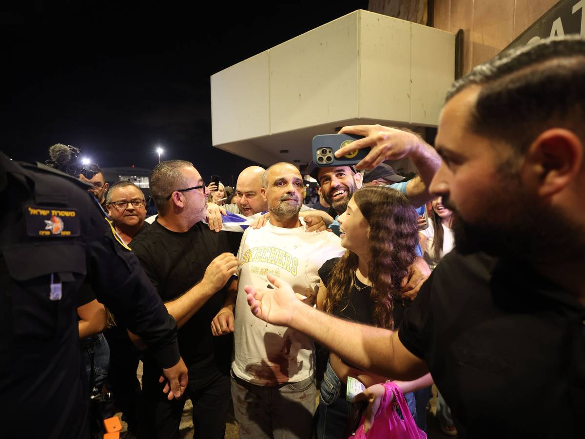 Yaniv Hayun (M), einer der Männer, die dazu beigetragen haben, den Angreifer in dem FlyDubai-Flugzeug auf dem Weg von den Vereinigten Arabischen Emiraten nach Israel außer Gefecht zu setzen, wird nach seiner Ankunft am Ben-Gurion-Flughafen begrüßt.