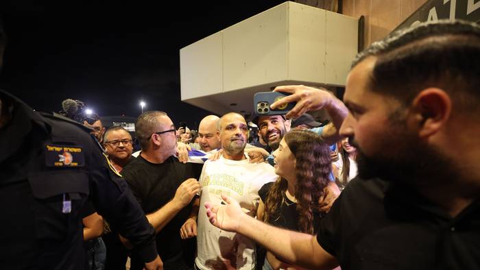 Yaniv Hayun (M), einer der Männer, die dazu beigetragen haben, den Angreifer in dem FlyDubai-Flugzeug auf dem Weg von den Vereinigten Arabischen Emiraten nach Israel außer Gefecht zu setzen, wird nach seiner Ankunft am Ben-Gurion-Flughafen begrüßt.