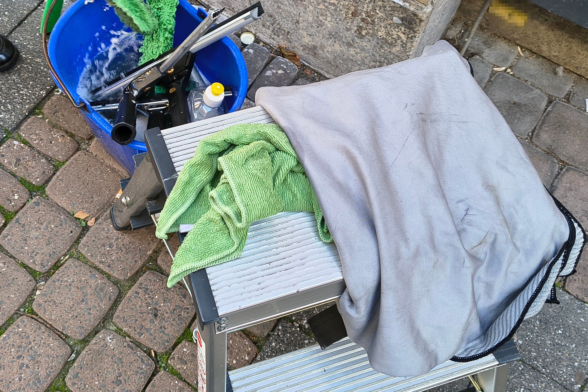 Die wichtigsten Putzutensilien: ein Eimer mit Wasser und Reinigungsmittel, ein Schwamm zum Einschäumen der Scheiben, Abzieher in verschiedenen Größen, ein Mikrofaser- und ein Poliertuch sowie eine kleine Leiter.