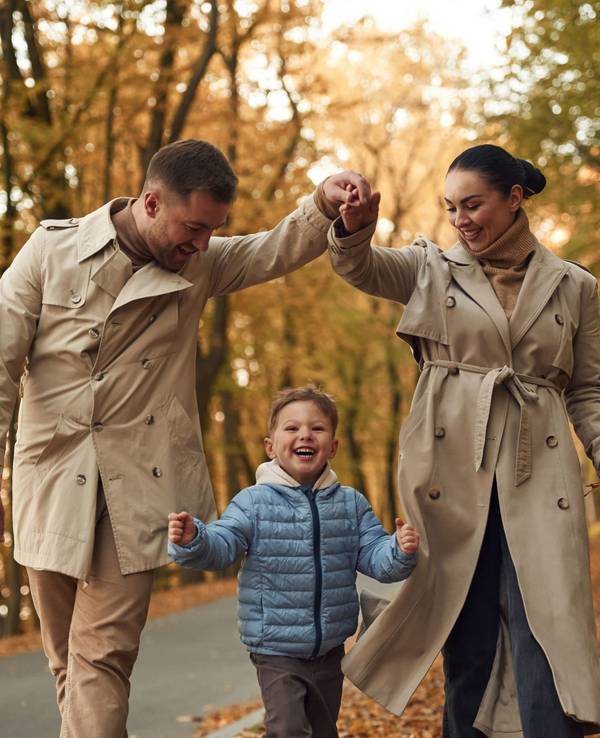 Eine schick angezogene Familie im Herbstwald