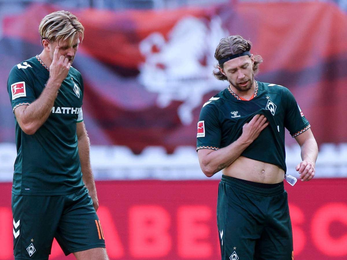 Niclas Füllkrug und Mitchell Weiser gehen enttäuscht über den Platz.