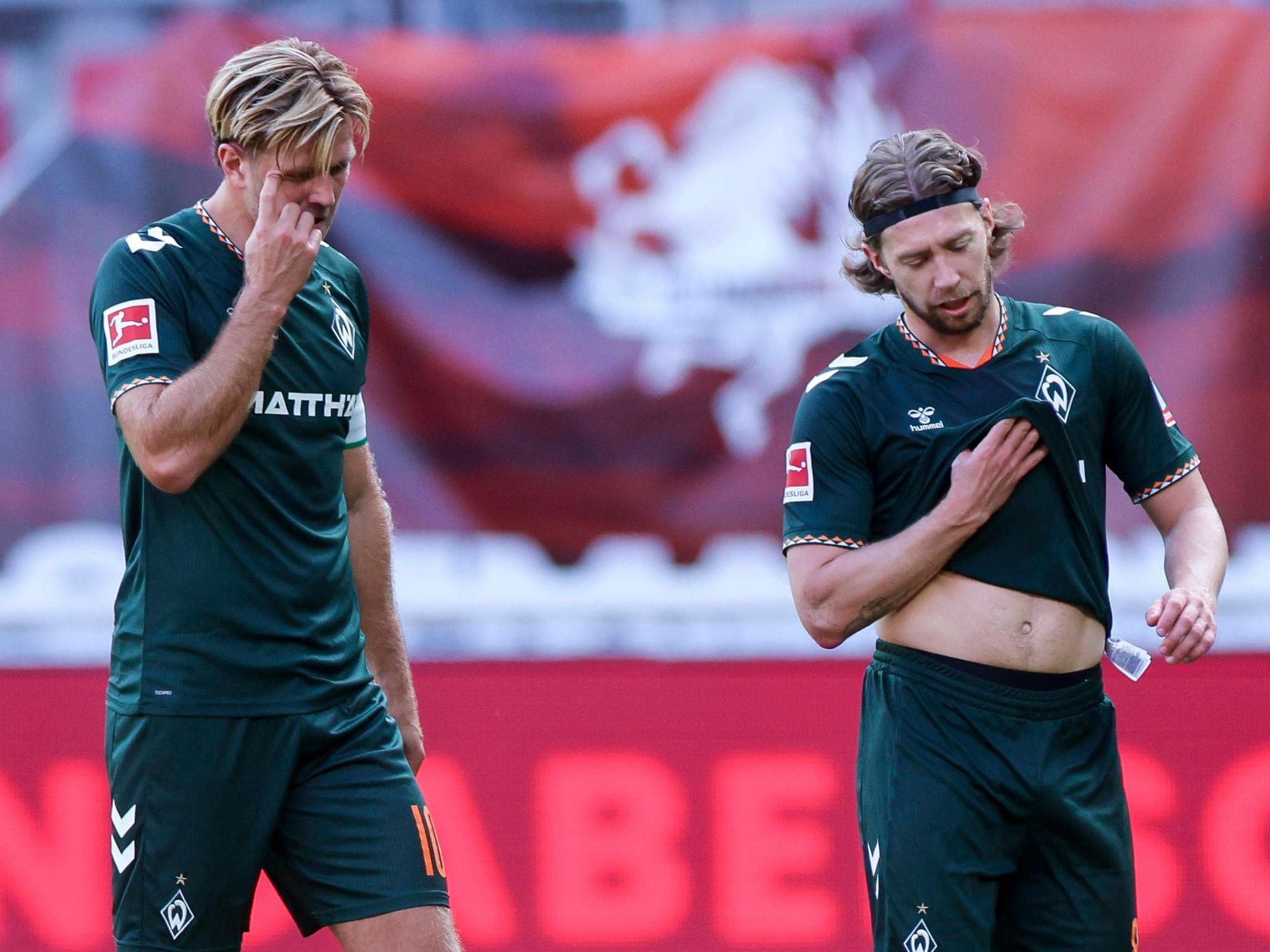 Niclas Füllkrug und Mitchell Weiser gehen enttäuscht über den Platz.