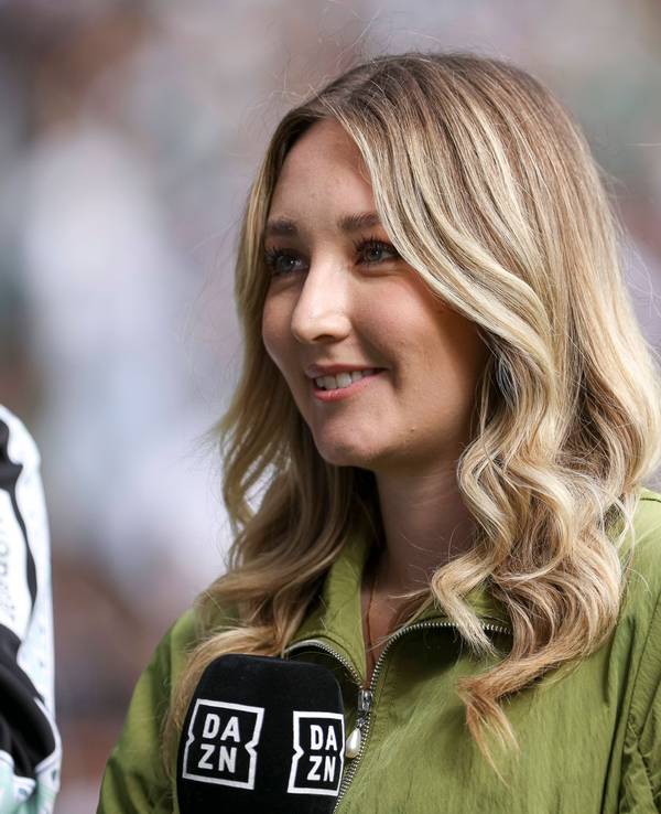 Lisa Tellers steht mit DAZN-Mikrofon am Spielfeldrand.
