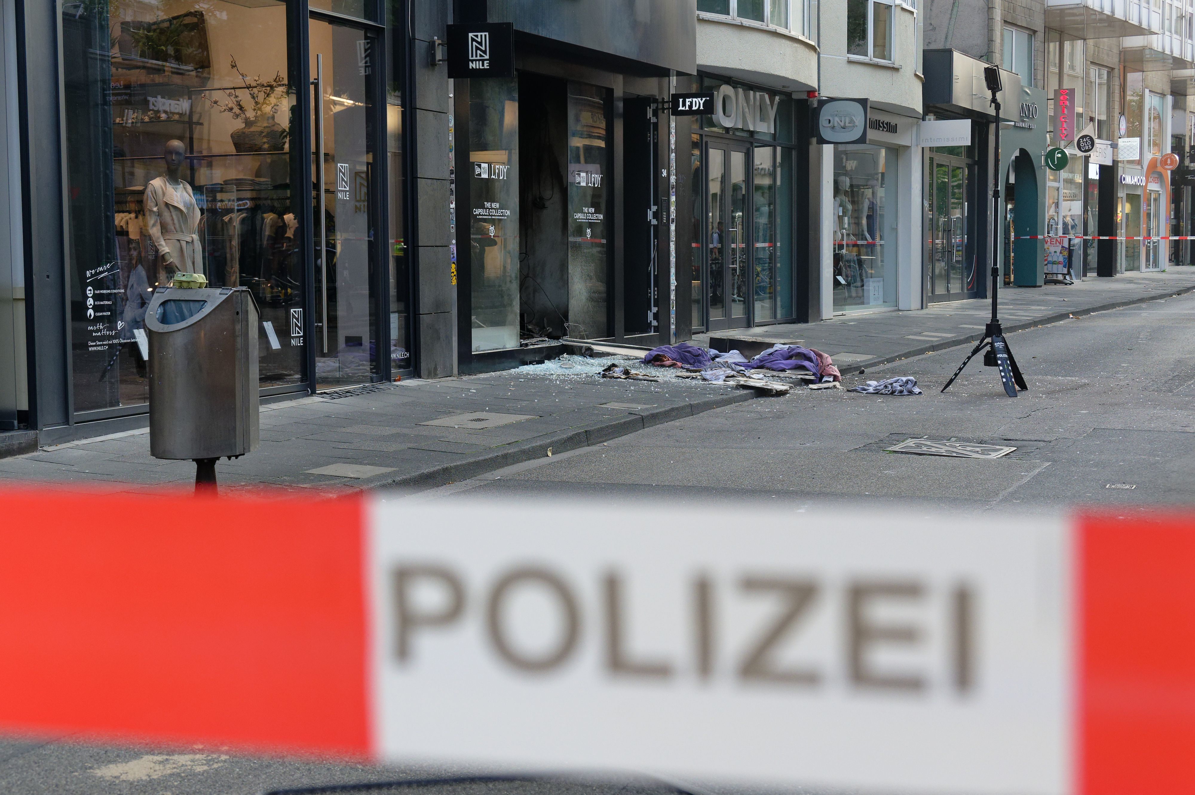 Scherben und Kleidungstücke liegen vor einem Geschäft in der Ehrenstraße in Köln.