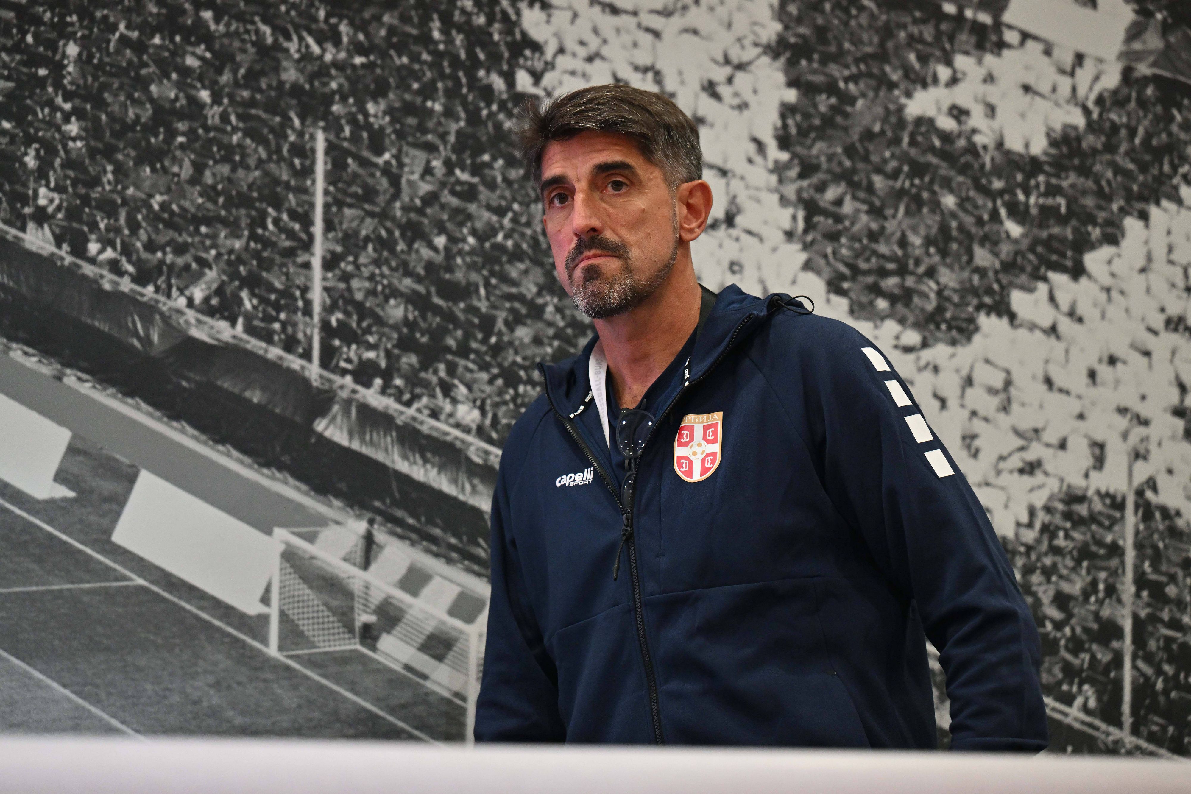 Veljko Paunović vor einer Wand, auf der eine Tribüne zu sehen ist.