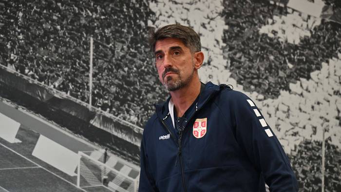 Veljko Paunović vor einer Wand, auf der eine Tribüne zu sehen ist.