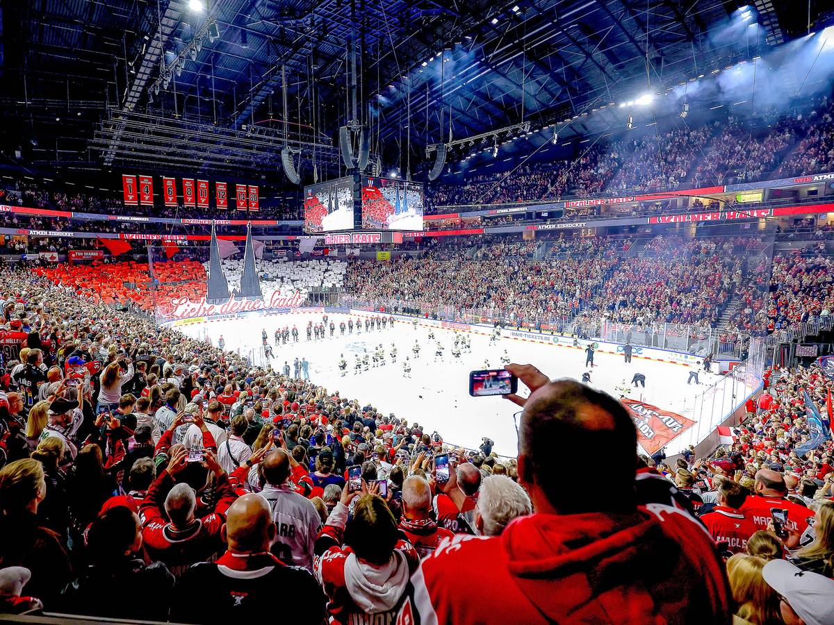 Ein Weitwinkel-Bild aus der vollen Lanxess-Arena, während die Haie-Fans auf der Südtribüne eine rot-weiße Dom-Choreografie zeigen.