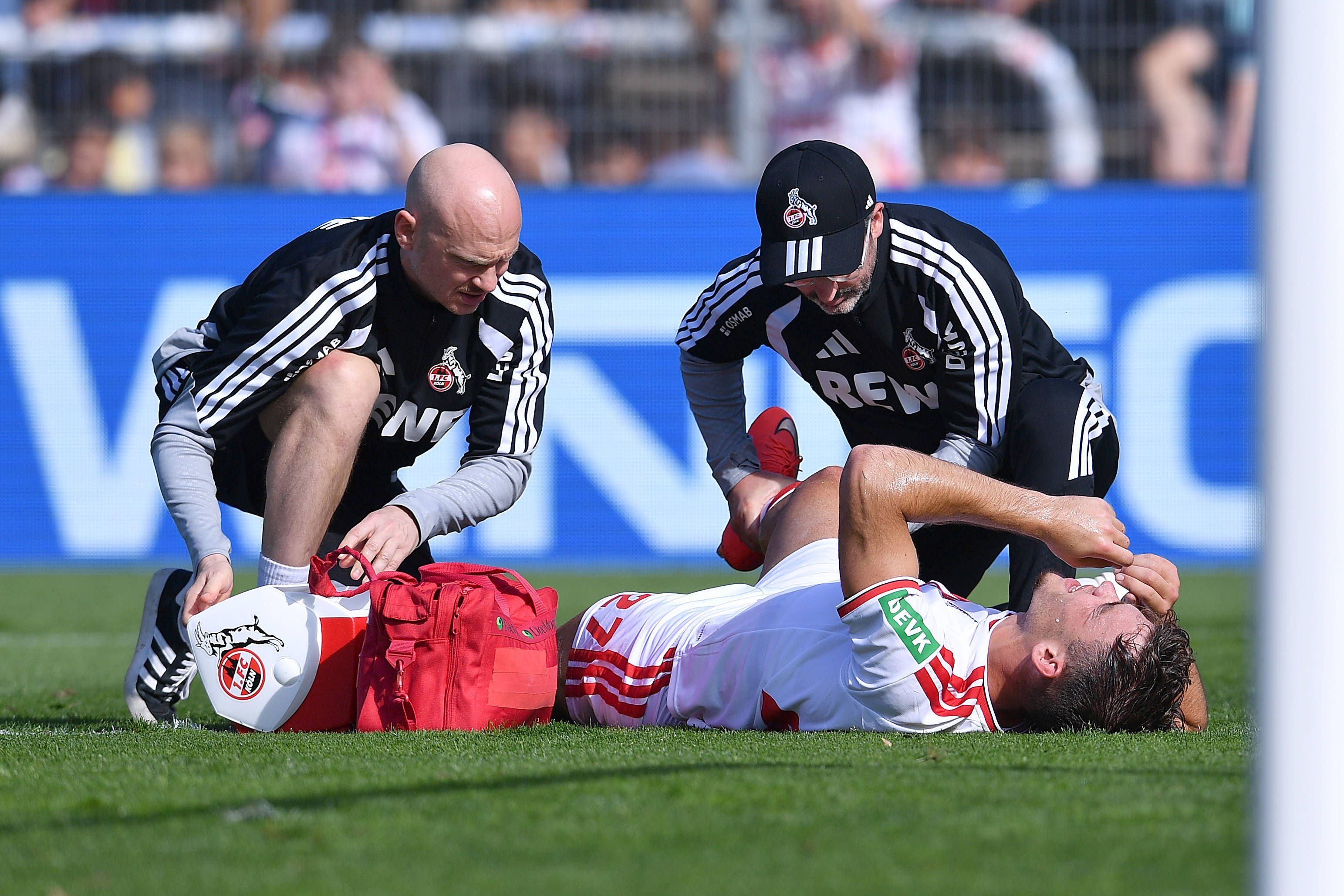 Thijs Dallinga (1. FC Köln)  verletzt am Boden: Zwei Betreuer kümmerten sich im Sportpark Höhenberg um ihn und kontrollierten sofort das Knie.
