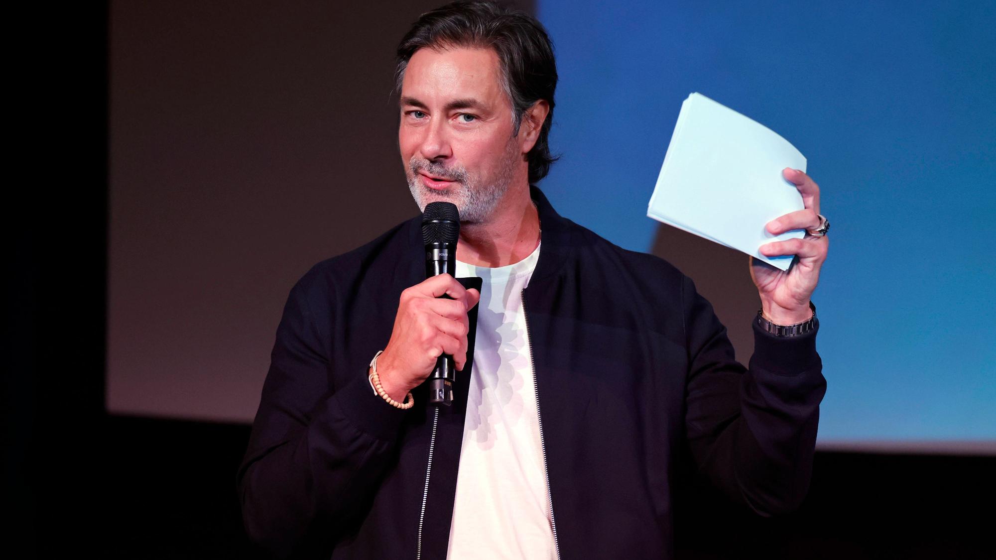 Marco Schreyl mit Mikrofon und Papieren