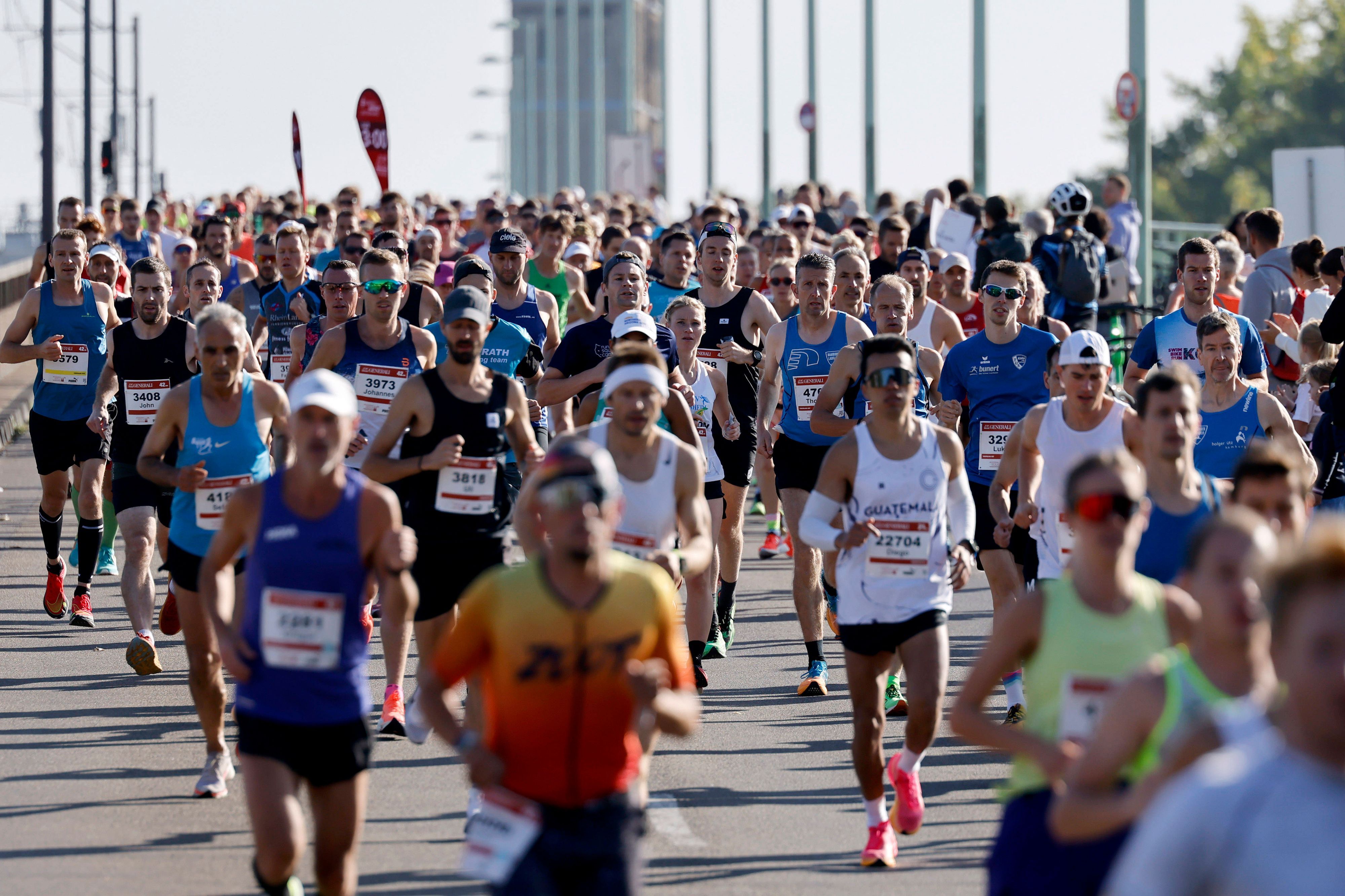 Zahlreiche Teilnehmer des „Generali Köln Marathon“ laufen über die Deutzer Brücke.