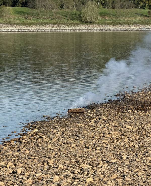 Brennende Phosphor-Brandbombe am Rheinufer in Neuss.