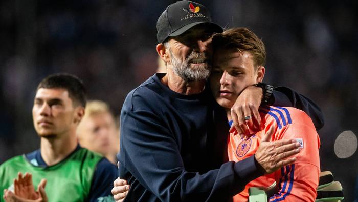 Jonas Urbig wird von seinem Trainer Jürgen Klopp umarmt.