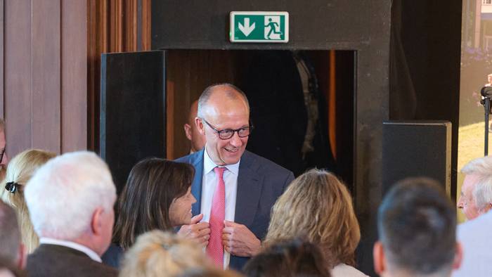 Bundeskanzler Friedrich Merz (CDU) spricht beim Besuch seines ehemaligen Gymnasiums, dem Friedrich-Spee-Gymnasium, in der Aula mit Ehrengästen