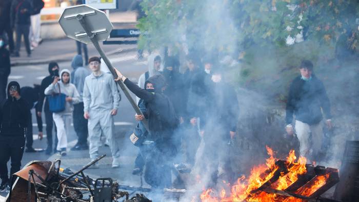 Ein Demonstrant wirft ein Stoppschild ins Feuer, während protestierende Schüler am 2. Oktober 2026 in der Nähe eines Gymnasiums in Brest im Westen Frankreichs eine Blockadeaktion durchführen. Seit Ende September protestieren Schüler in Frankreich vor Schulen gegen Missstände.