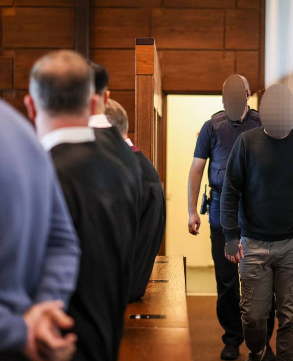 Ein Angeklagter (r) wird von einem Justizbeamten in den Gerichtssaal gebracht. Der Raubüberfall in einer Hürther Lagerhalle gilt als Auslöser einer massiven Gewaltspirale, die als „Kölner Drogenkrieg“ bekannt wurde und im Sommer 2024 Köln und die Region in Atem hielt.
