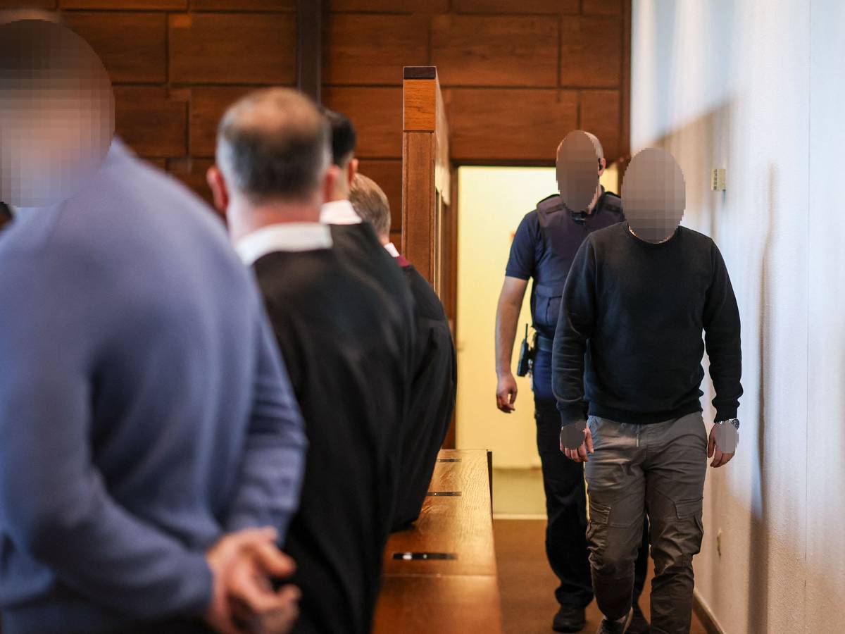 Ein Angeklagter (r) wird von einem Justizbeamten in den Gerichtssaal gebracht. Der Raubüberfall in einer Hürther Lagerhalle gilt als Auslöser einer massiven Gewaltspirale, die als „Kölner Drogenkrieg“ bekannt wurde und im Sommer 2024 Köln und die Region in Atem hielt.