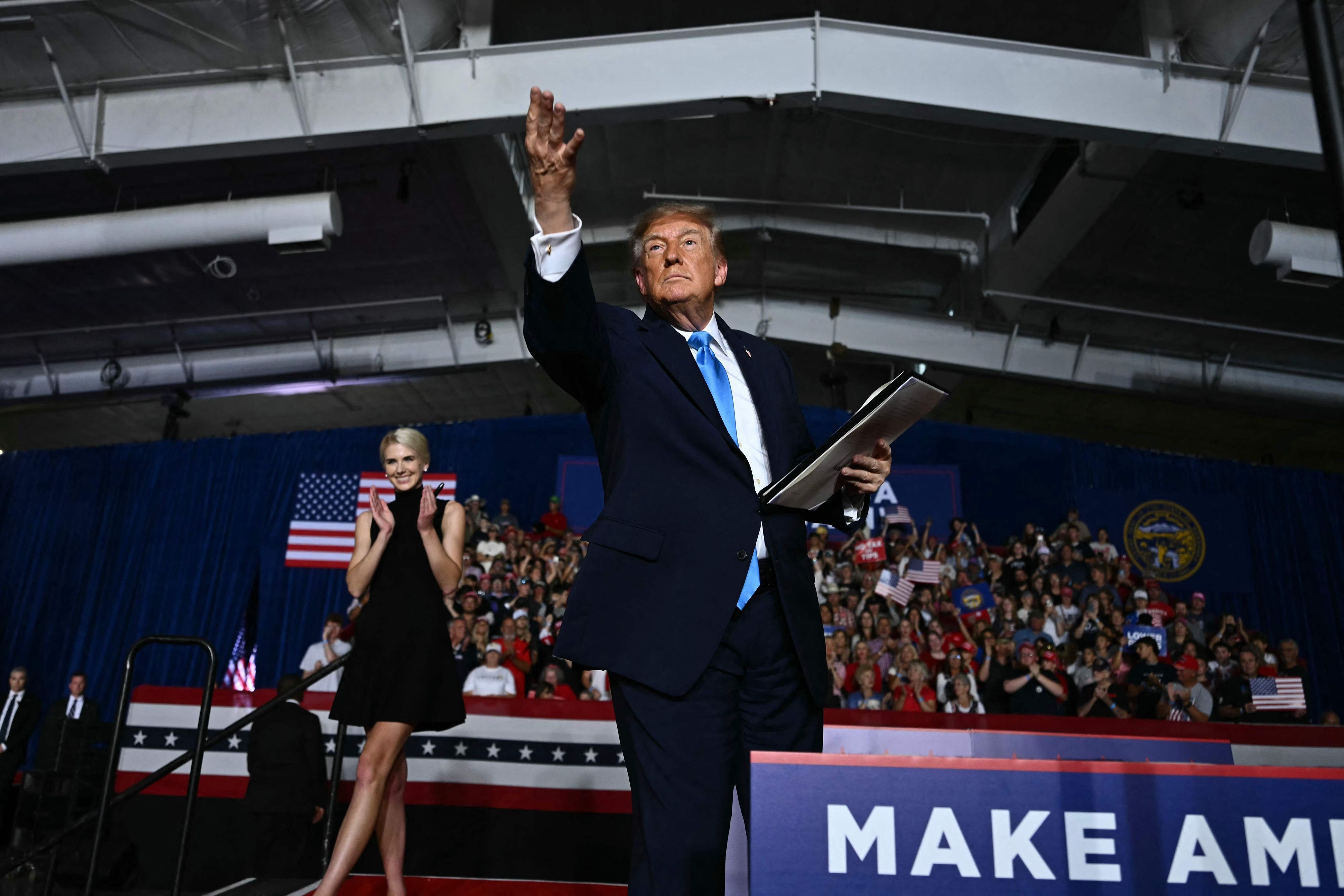 TOPSHOT - US President Donald Trump throws a pen into the crowd after he signed an executive order during a campaign rally at Pinnacle Bank Expo Center in Grand Island, Nebraska, on October 5, 2026. (Photo by Kent NISHIMURA / AFP)