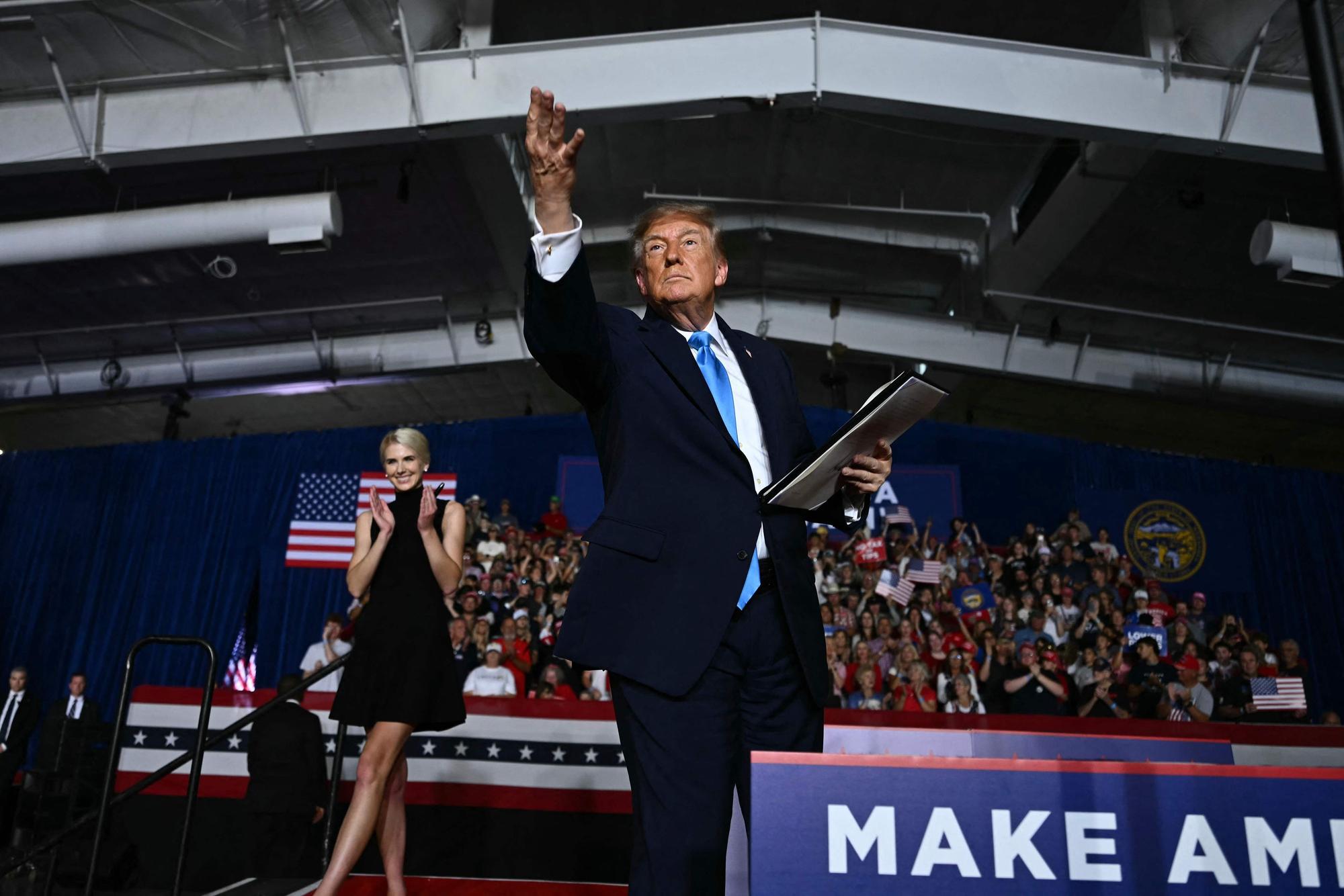 TOPSHOT - US President Donald Trump throws a pen into the crowd after he signed an executive order during a campaign rally at Pinnacle Bank Expo Center in Grand Island, Nebraska, on October 5, 2026. (Photo by Kent NISHIMURA / AFP)