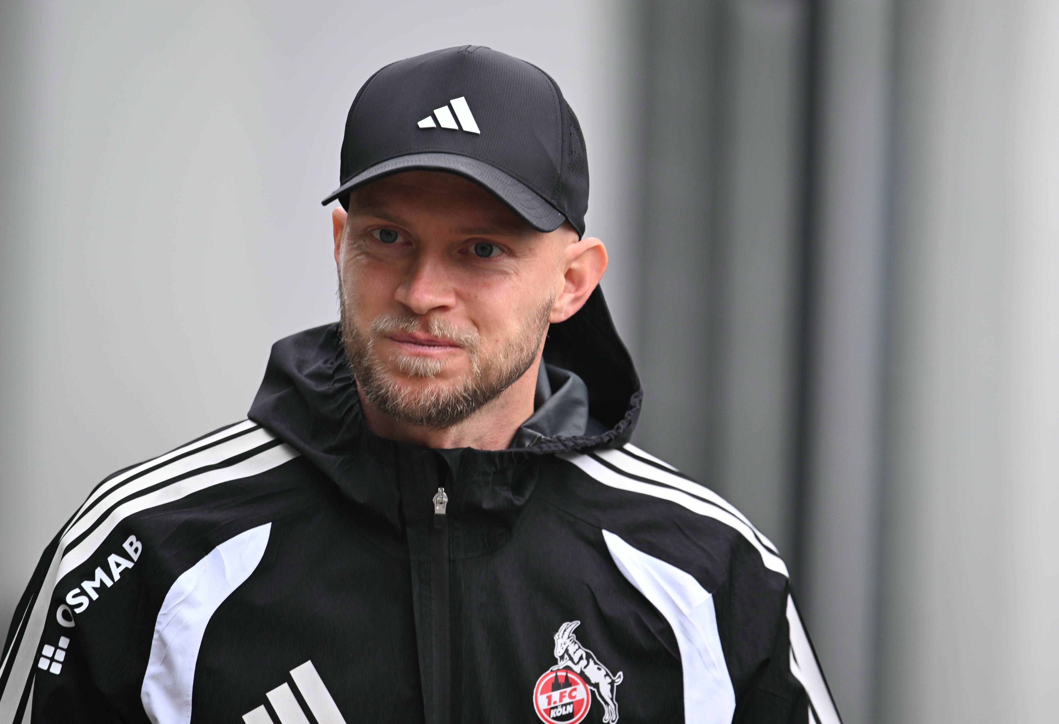 René Wagner beim Training des 1. FC Köln mit Regenjacke und Kappe.