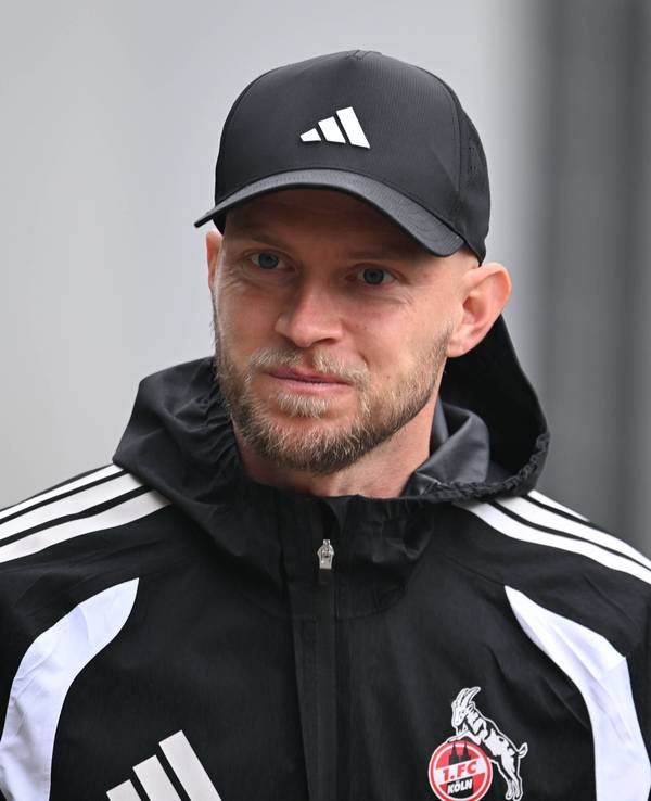 René Wagner beim Training des 1. FC Köln mit Regenjacke und Kappe.