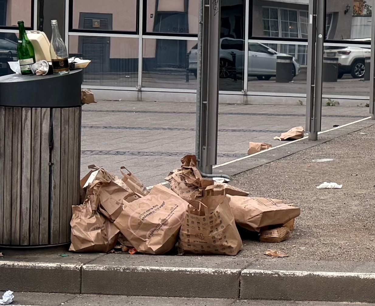 Jede Menge Nhas-Tüten liegen neben dem Mülleimer auf dem „Maus“-Platz.