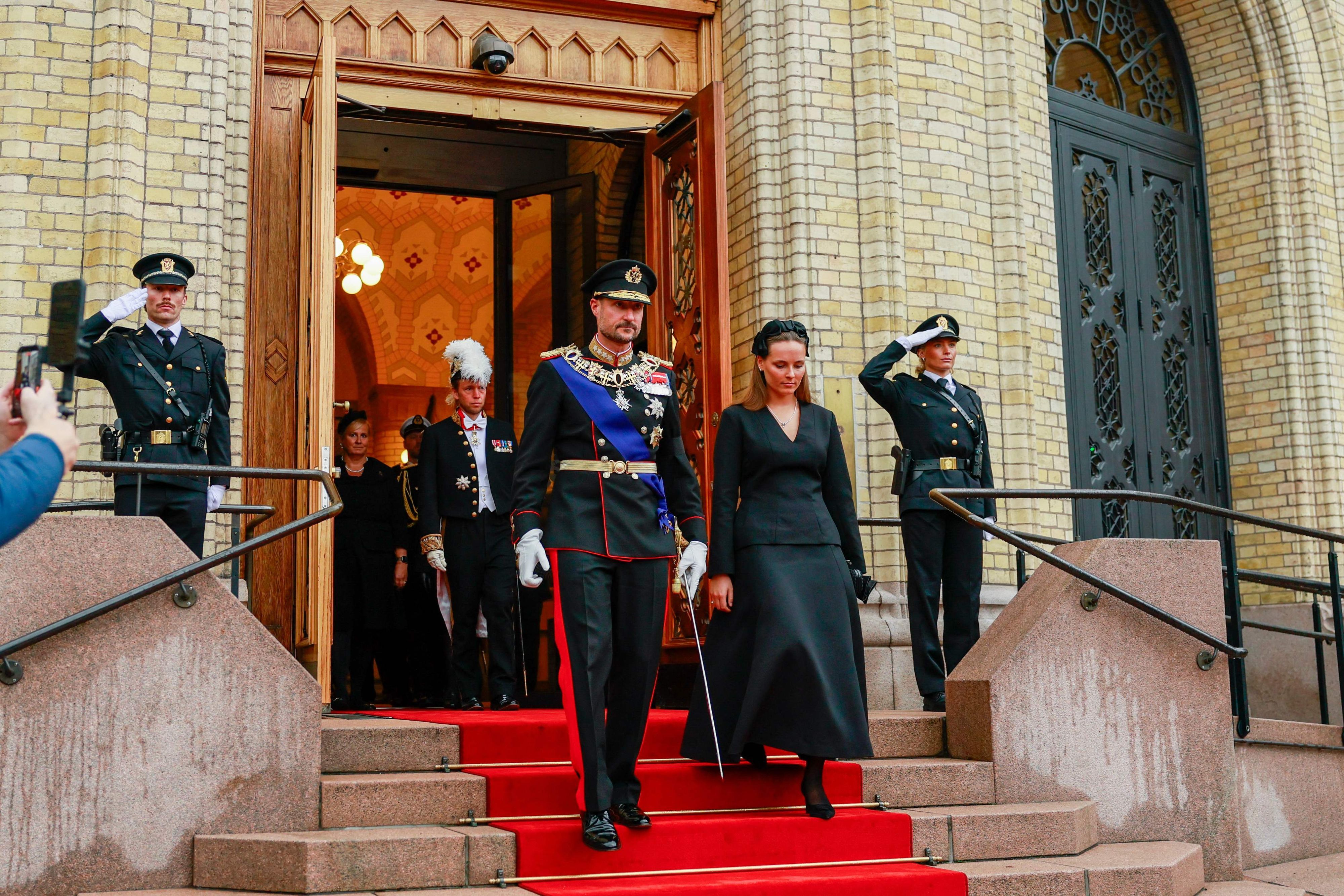König Haakon und Kronprinzessin Ingrid Alexandra gehen nebeneinander.