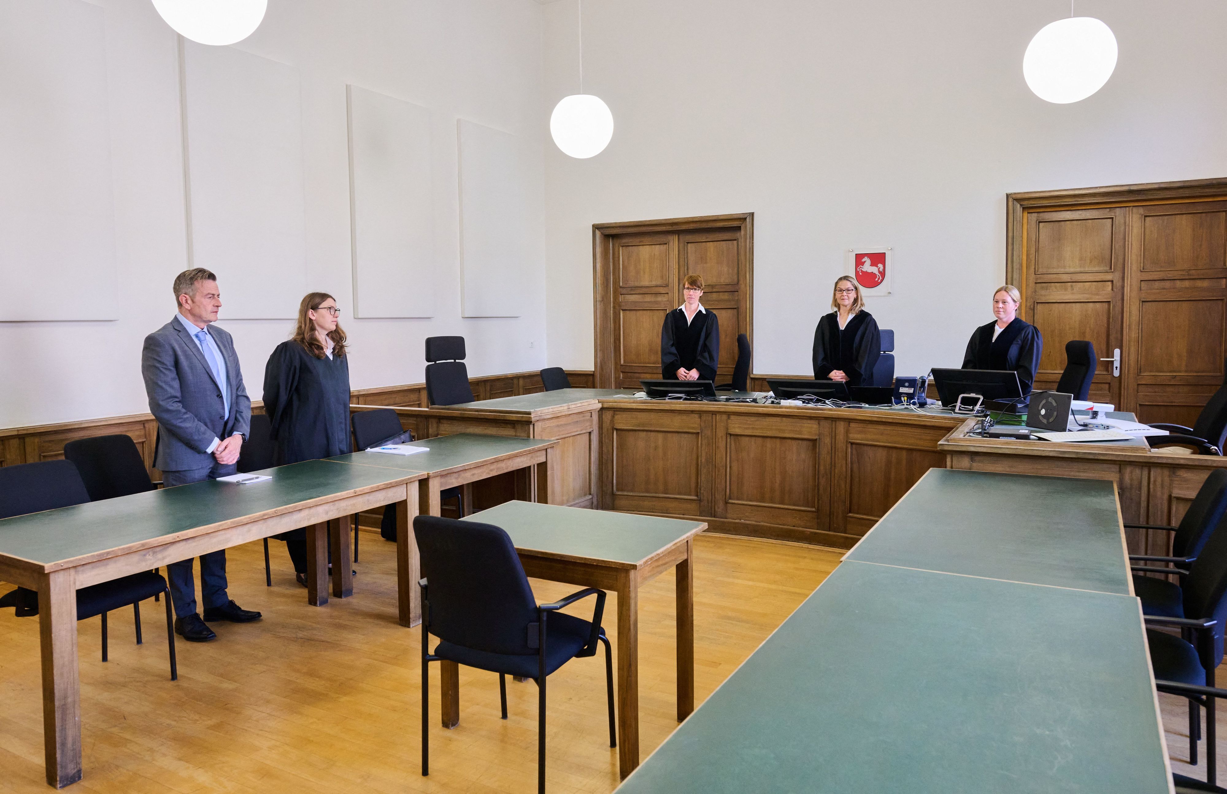 Menschen stehen im Gerichtssaal.