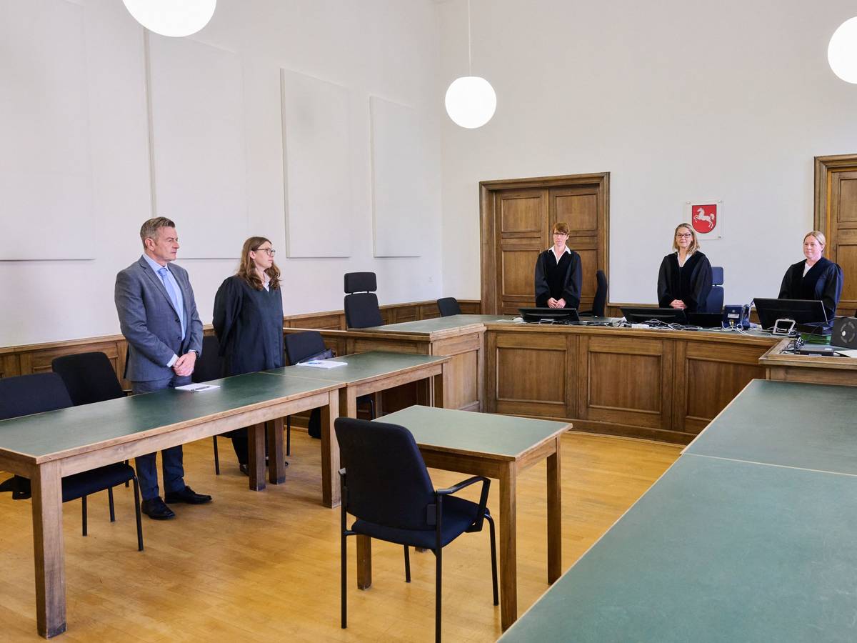 Menschen stehen im Gerichtssaal.