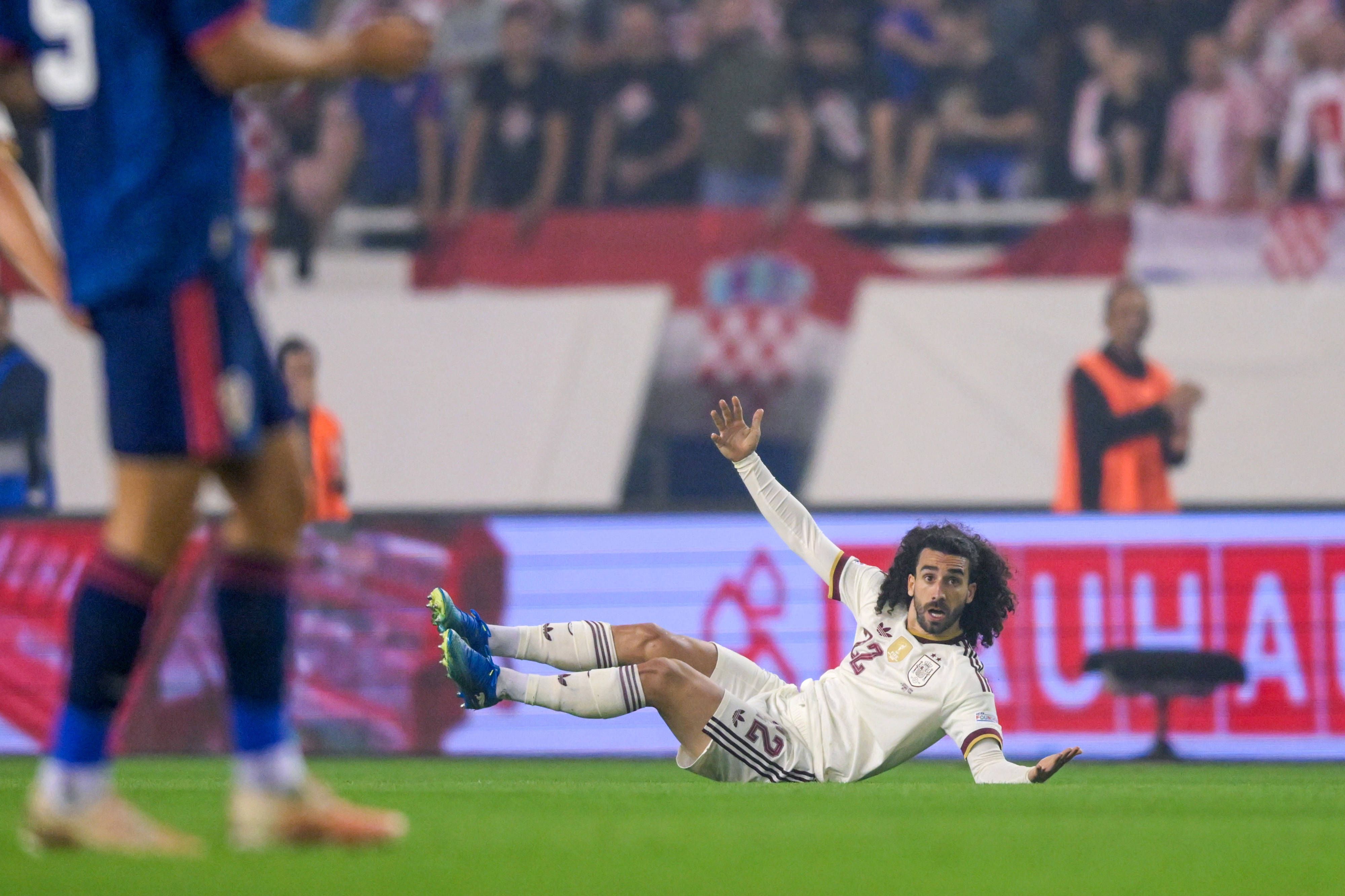 Marc Cucurella liegt auf dem Boden und breitet die Arme aus.