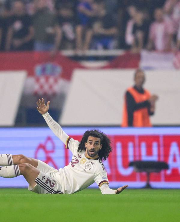 Marc Cucurella liegt auf dem Boden und breitet die Arme aus.