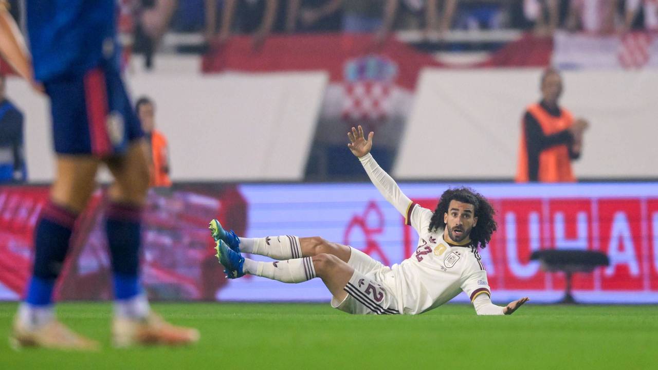 Marc Cucurella liegt auf dem Boden und breitet die Arme aus.
