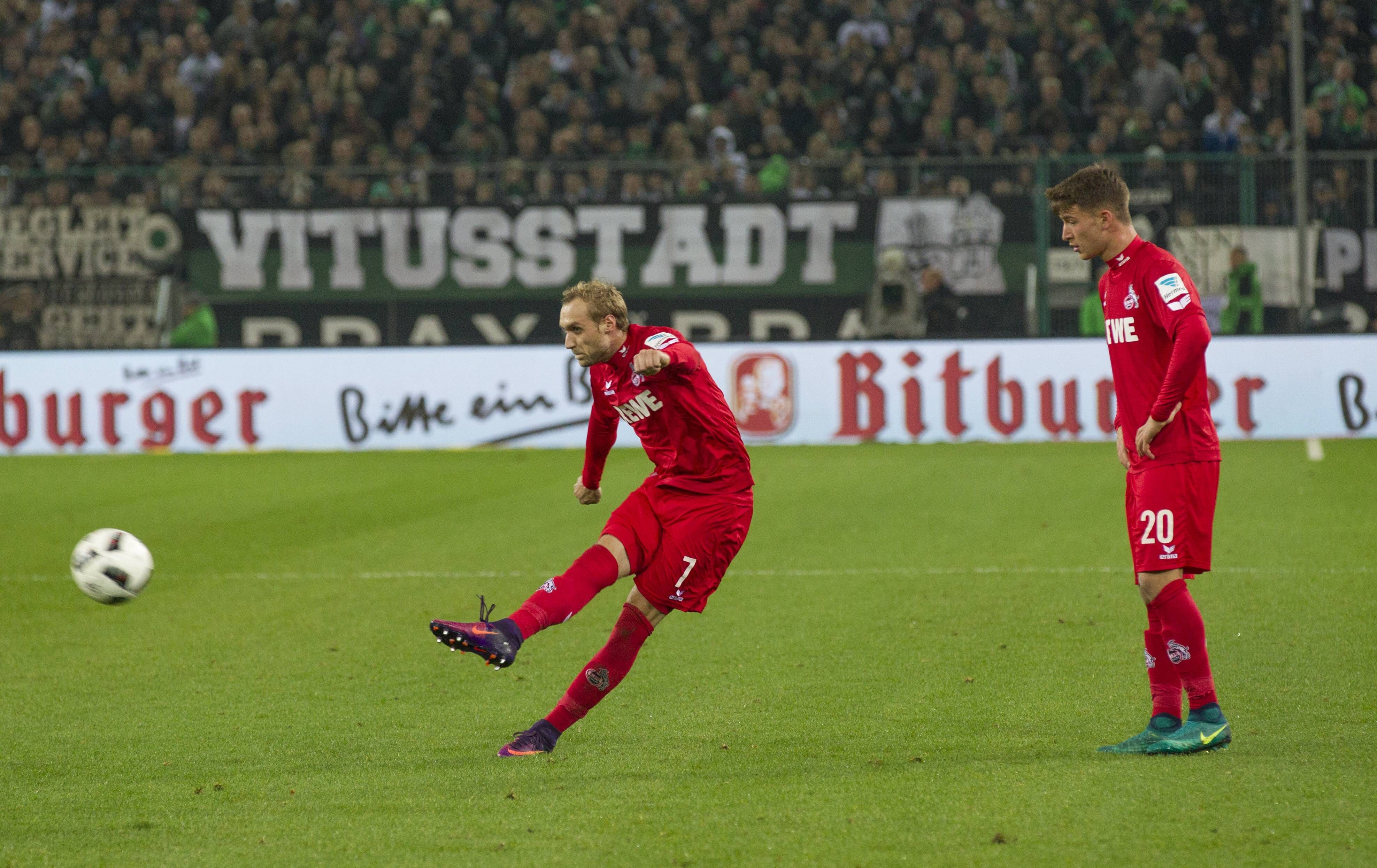 Marcel Risse schießt einen Freistoß, Salih Özcan steht daneben.