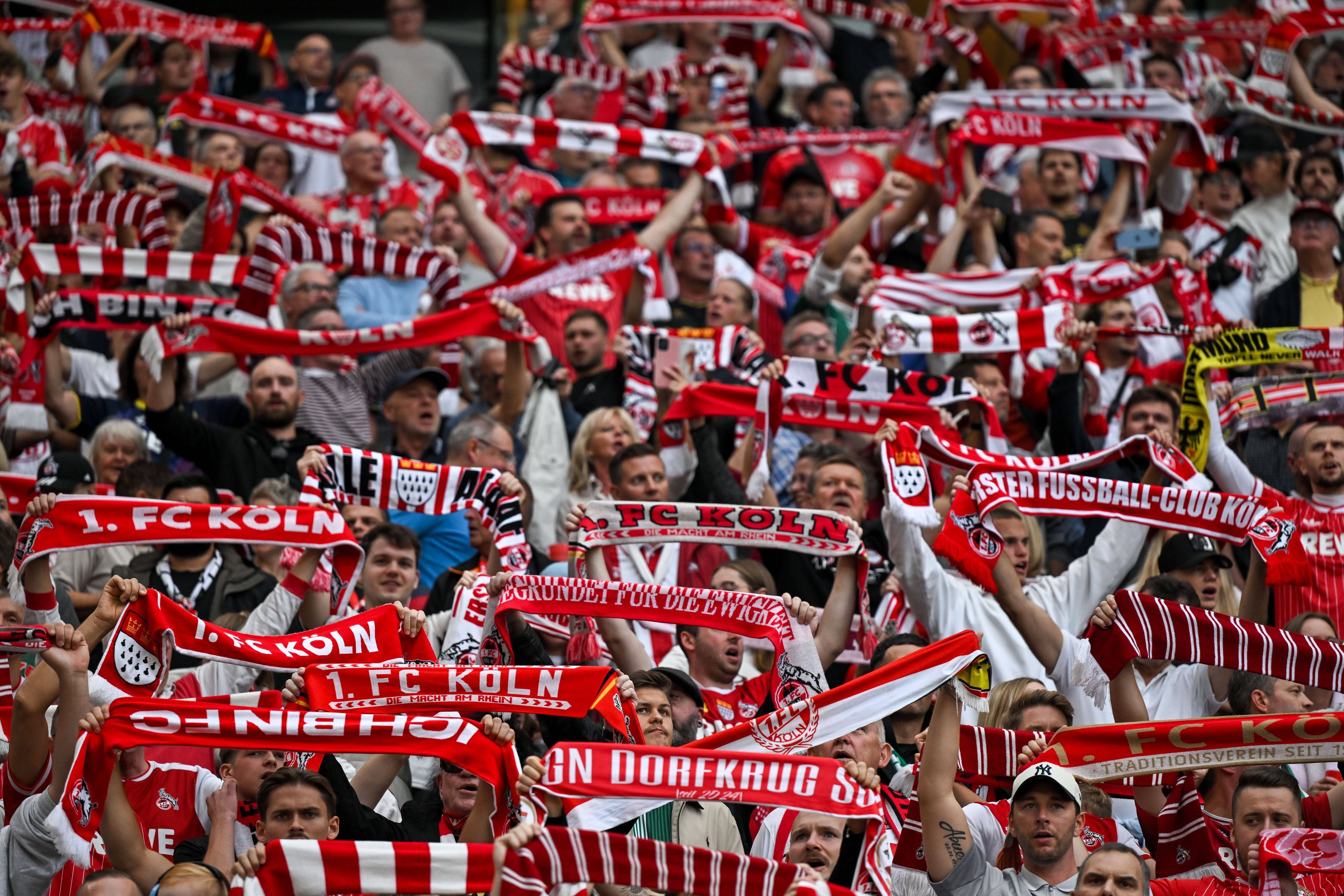 1. FC Köln Fans halten ihre Schals hoch.