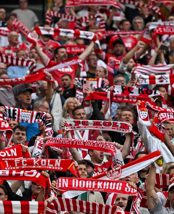 1. FC Köln Fans halten ihre Schals hoch.