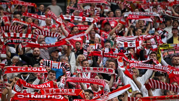 1. FC Köln Fans halten ihre Schals hoch.