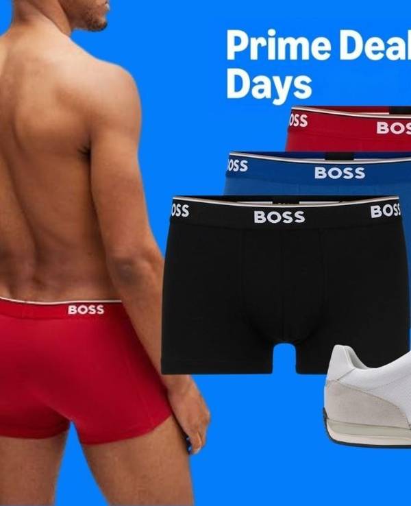 Ein Mann trägt rote BOSS-Boxershorts; daneben sind Boxershorts in Schwarz, Blau und Rot, mehrere T-Shirts und ein weißer Sneaker vor blauem Hintergrund zu sehen. Die Grafik zeigt außerdem den Prime-Deal-Days- und den Amazon-Schriftzug.