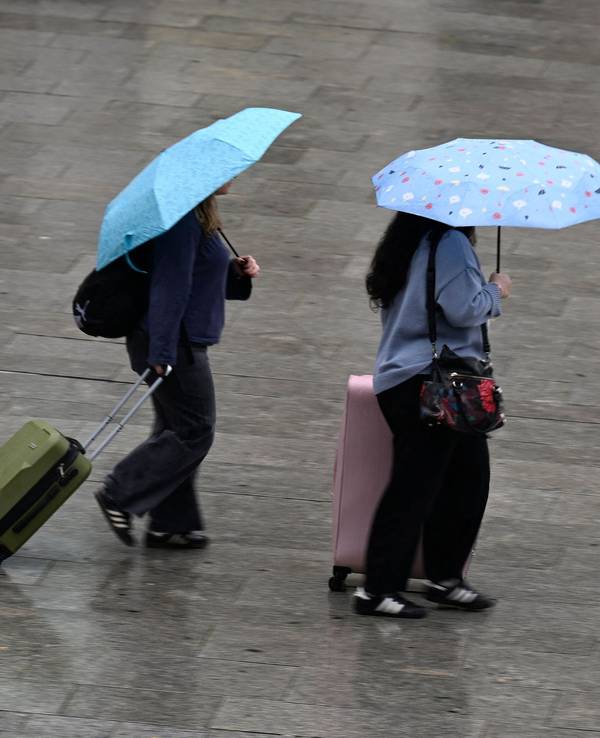 Köln: Passanten schützen sich auf dem Bahnhofsvorplatz mit Schirmen vor dem Regen (Archivbild)