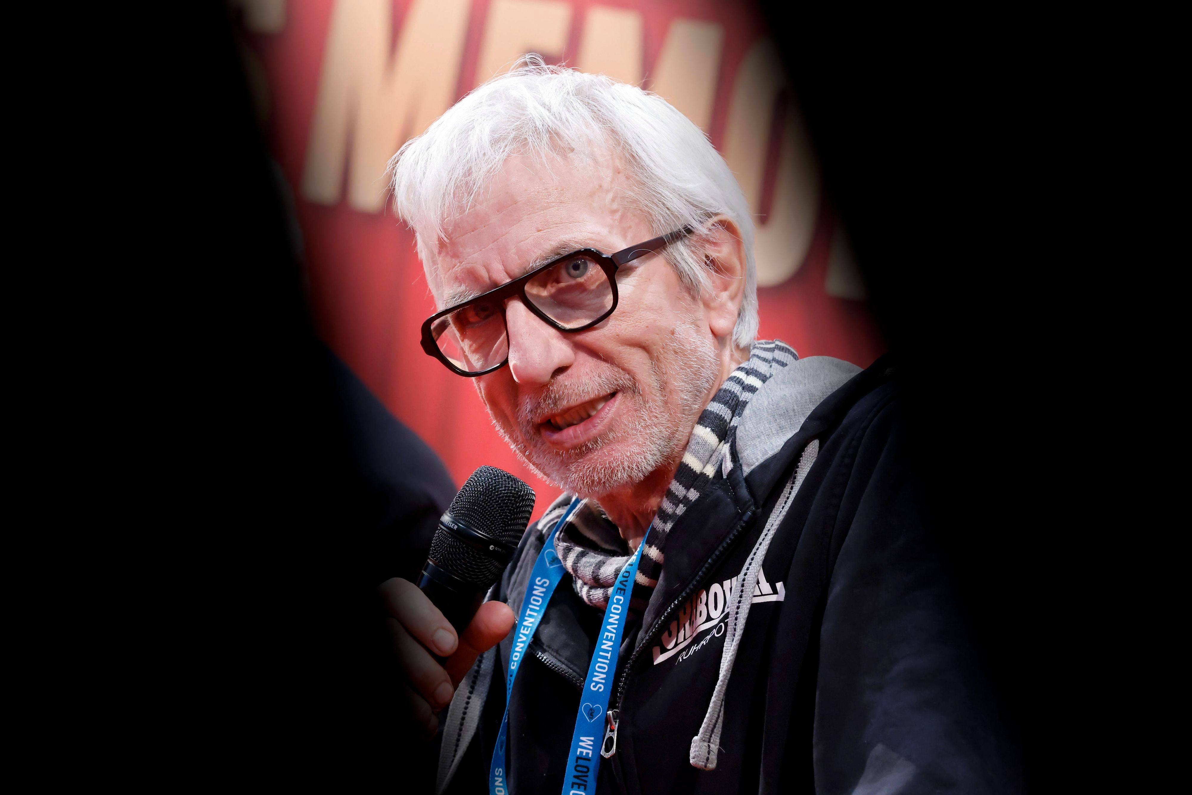 Ralf Richter mit Mikrofon, Brille und Schal