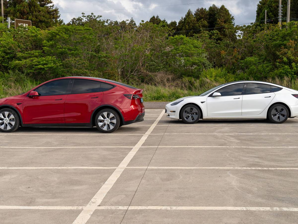 Tesla Model Y und Tesla Model 3 auf einem Parkplatz.
