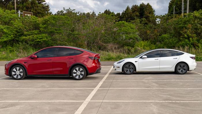 Tesla Model Y und Tesla Model 3 auf einem Parkplatz.