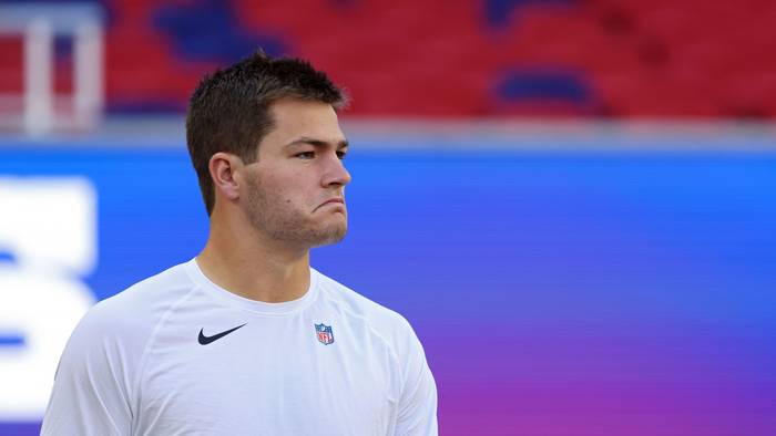 NFL‑Quarterback Drake Maye von den New England Patriots blickt beim Warmmachen zu seinen Mitspielern.