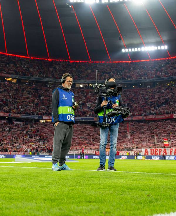 Ein Kamerateam filmt in der Champions League den Spielball auf dem Rasen.