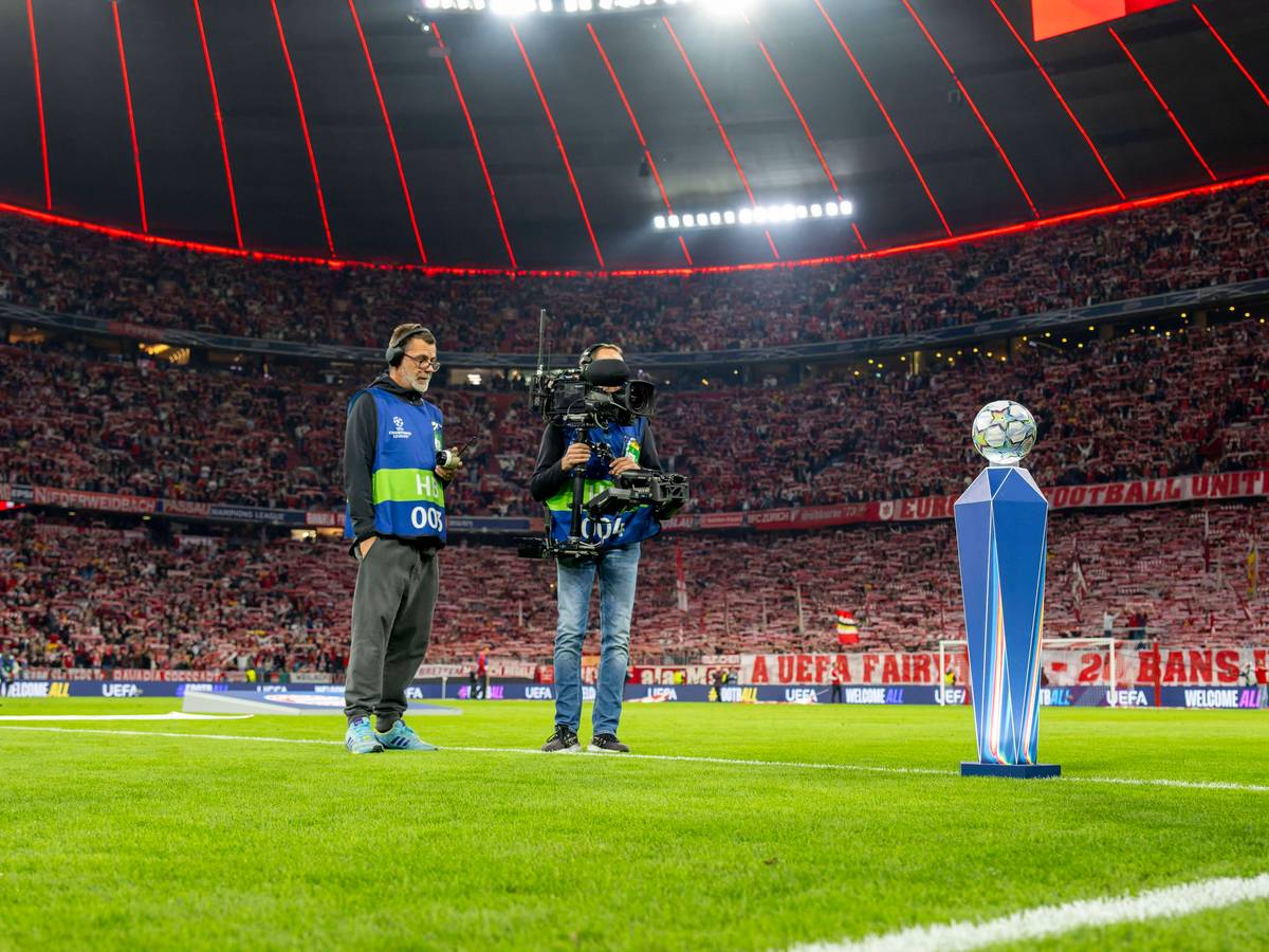 Ein Kamerateam filmt in der Champions League den Spielball auf dem Rasen.