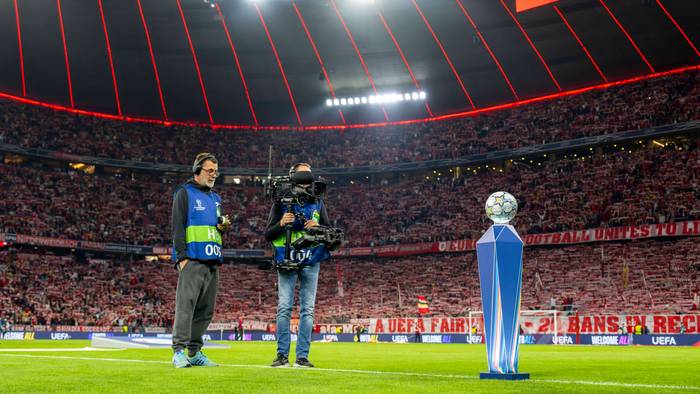 Ein Kamerateam filmt in der Champions League den Spielball auf dem Rasen.